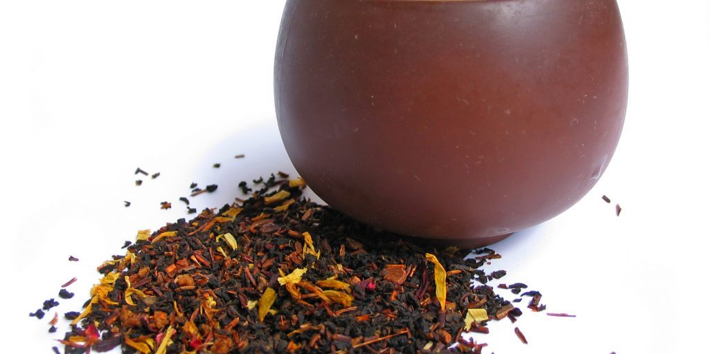 A mix black and flower tea leaves with cup of tea